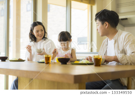 一家人其樂融融地圍坐在餐桌旁 一家人其樂融融地圍坐在餐桌旁 133349550