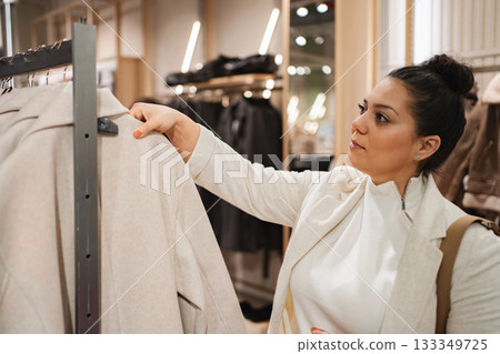 Woman exploring fashion choices while shopping in a boutique Woman exploring fashion choices while shopping in a boutique 133349725