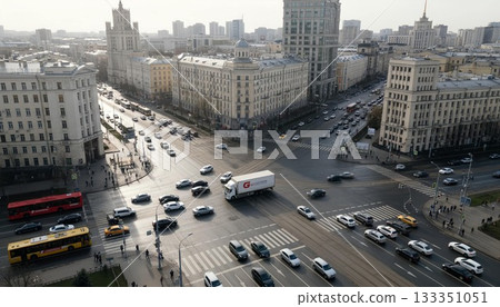 Busy intersection in a bustling urban city during midday traffic with a mix of vehicles and pedestrians 133351051