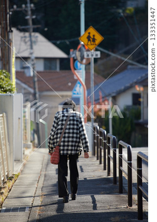 秋日的清晨，一位老婦人在居民區散步。 133351447