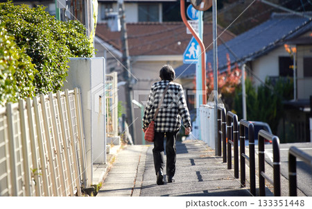 秋日的清晨,一位老婦人在居民區散步。 秋日的清晨,一位老婦人在居民區散步。 133351448