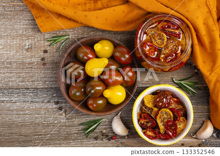 Flatlay of dried cherry tomatoes in a jar and plate with ingredients. 133352546