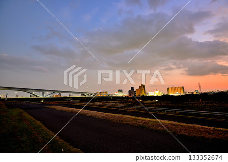 Evening view of the Toneri Liner and Ogi Ohashi Bridge from the Arakawa River bank 133352674