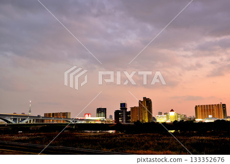 Evening view of the Toneri Liner and Ogi Ohashi Bridge from the Arakawa River bank 133352676