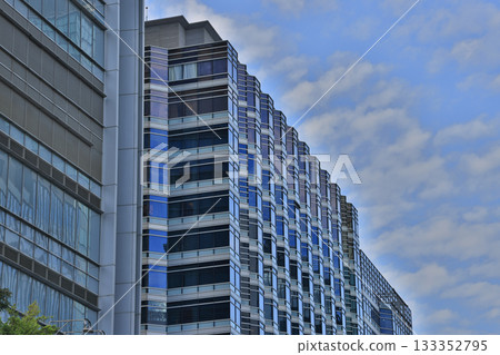 Glass Office Building Facade Shaped by Repeating Blue Windows Nov 15 2025 Glass Office Building Facade Shaped by Repeating Blue Windows Nov 15 2025 133352795
