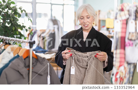 Regular customer senior woman chooses color and style of trousers 133352964
