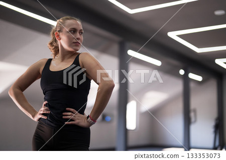 Female athlete posing confidently in modern fitness studio during a workout session 133353073