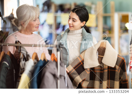 Two women of different ages choosing clothes in a store 133353204