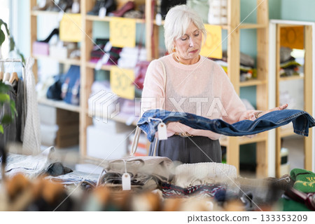 Regular customer senior woman chooses color and style of jeans trousers Regular customer senior woman chooses color and style of jeans trousers 133353209