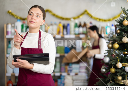 Woman seller with assistant taking inventory with tablet in store Woman seller with assistant taking inventory with tablet in store 133353244