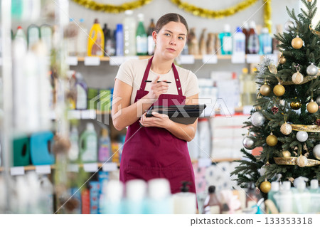 Female seller with tablet, plans to replenish restock stores inventory on Christmas Eve Female seller with tablet, plans to replenish restock stores inventory on Christmas Eve 133353318