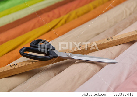Tailoring tools, scissors and wooden ruler on colorful fabrics, textile industry concept, sewing studio, fashion design, dressmaking, garment production, handmade, craft projects, hobby 133353415