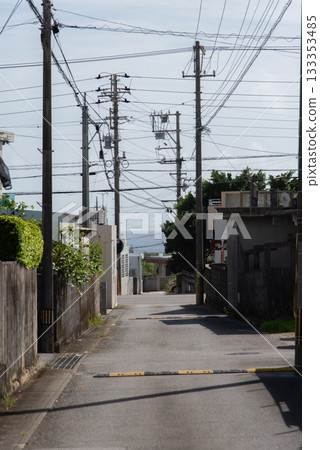 天氣晴朗時，鄉村小巷裡電線桿和房屋投下斑駁的影子，遠處可以看到大海。 133353485