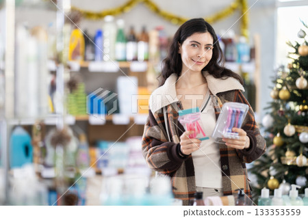 Woman buying a razor on the background of a Christmas tree Woman buying a razor on the background of a Christmas tree 133353559