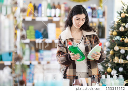 Young woman chooses dishwashing detergent in store Young woman chooses dishwashing detergent in store 133353652