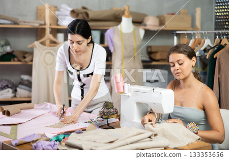 Two female tailors creating custom garments in workshop 133353656