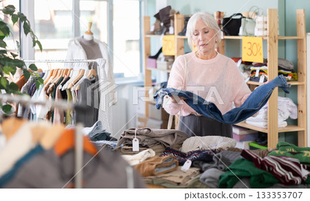 Mature woman choosing jeans in a clothing store Mature woman choosing jeans in a clothing store 133353707