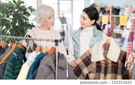 Elderly and young woman choosing coat or down jacket 133353835