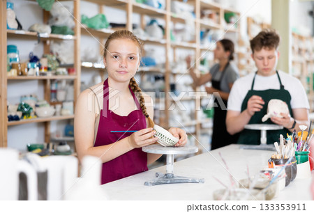 Teenagers are interested in making dishes from clay in pottery workshop Teenagers are interested in making dishes from clay in pottery workshop 133353911