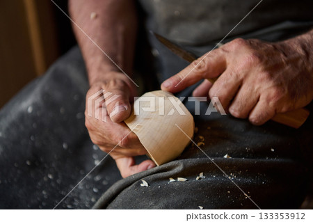 Close up of craftsman hands using knife to carve wood, woodworking process, handmade craft, wood carving, creative hobby, carpentry, DIY project, art, skill, detail shot Close up of craftsman hands using knife to carve wood, woodworking process, handmade craft, wood carving, creative hobby, carpentry, DIY project, art, skill, detail shot 133353912