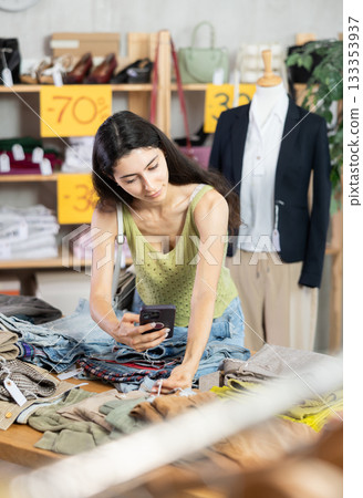 woman with long hair is eating at the counter with pants and scanning a barcode woman with long hair is eating at the counter with pants and scanning a barcode 133353937