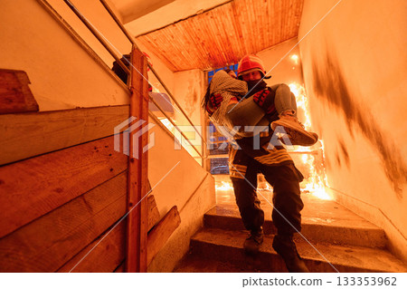 Brave firefighter rescuing a woman from a burning building, carrying her down the stairs, showcasing heroism and fire safety, emergency response, dramatic scene, danger and rescue operation 133353962