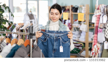 Armenian woman buys stylish jeans in a clothing store 133353982