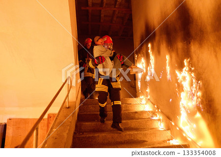 Courageous firefighter carrying a rescued woman down a burning staircase during an emergency evacuation, symbolizing bravery, heroism, and dedication to saving lives in dangerous situations. Courageous firefighter carrying a rescued woman down a burning staircase during an emergency evacuation, symbolizing bravery, heroism, and dedication to saving lives in dangerous situations. 133354008