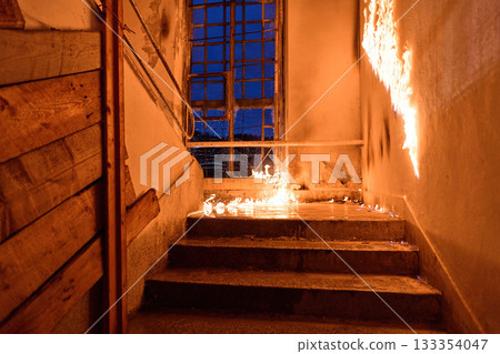 Burning staircase with flames, fire damage in an abandoned building, danger, destruction, and risk, interior scene with window and damaged walls, dramatic light. 133354047