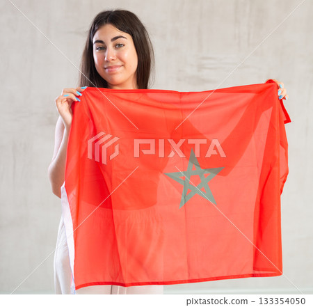 Happy young woman with flag of Monaco against unicoloured background Happy young woman with flag of Monaco against unicoloured background 133354050