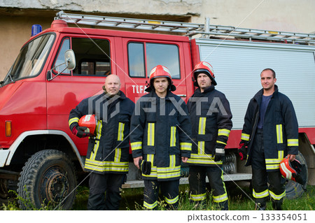 Firefighters in uniform and helmets posing in front of fire truck, emergency service team, rescue operation, fire safety, urban scene, outdoor, teamwork and bravery concept Firefighters in uniform and helmets posing in front of fire truck, emergency service team, rescue operation, fire safety, urban scene, outdoor, teamwork and bravery concept 133354051