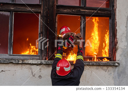 Firefighters battling flames in burning building, risking lives, firemen extinguishing blaze, emergency response, danger, rescue operation, dramatic scene, firefighters in action 133354134