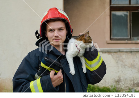 Firefighter rescues a cat from a burning building, hero holding a rescued pet, rescue operation, urban scene, firefighter in uniform, saving animal, outdoor setting 133354195
