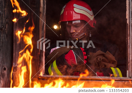 Firefighter rescuing a baby from burning building, fireman in action saving child, emergency situation, fire in house, danger, rescue operation, outdoor scene Firefighter rescuing a baby from burning building, fireman in action saving child, emergency situation, fire in house, danger, rescue operation, outdoor scene 133354203