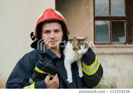 Firefighter rescues a cat from a burning building, hero holding a rescued pet, rescue operation, urban scene, firefighter in uniform, saving animal, outdoor setting 133354236