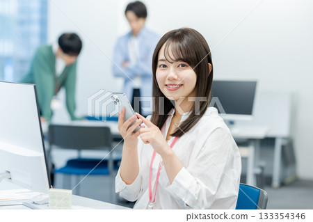 Business woman with a smartphone in the office Business woman with a smartphone in the office 133354346