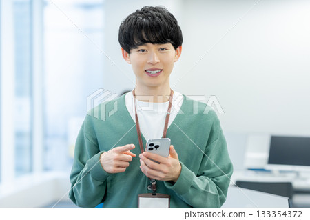 A businessman who uses a smartphone in the office 133354372