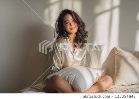 A smiling woman in bed in the morning - creating a natural lifestyle and a pleasant awakening 133354642