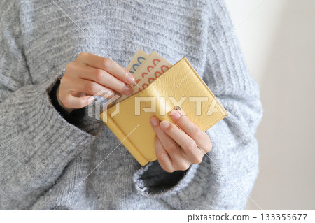 A housewife taking money out of her wallet 133355677