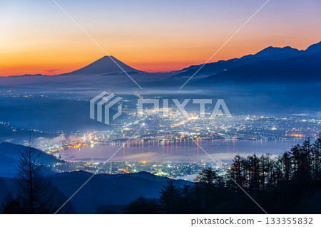 黎明時分，從高峠高原望去，諏訪湖上空雲海翻騰，遠處富士山巍峨聳立。 133355832