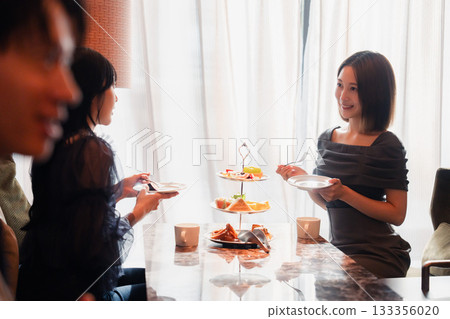 Young people having a girls' get-together at a hotel afternoon tea 133356020