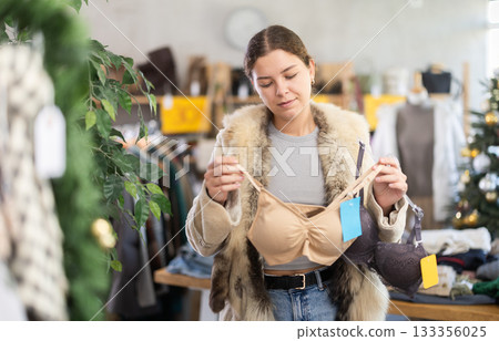 Young girl near showcase pick out and buying ladys bra, New Year eve 133356025