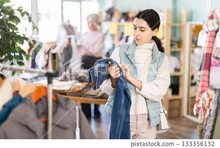 Young woman choosing jeans in clothing store 133356132