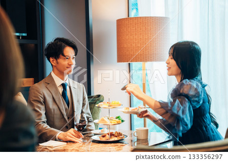 A man enjoying afternoon tea with a young woman A man enjoying afternoon tea with a young woman 133356297