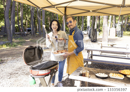 Family having a BBQ at a campsite 133356397