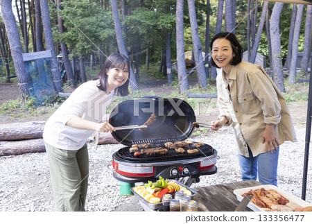 Family having a BBQ at a campsite 133356477