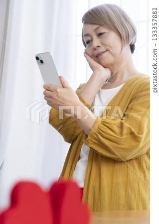 Senior woman using a matching app on her smartphone Senior woman using a matching app on her smartphone 133357881