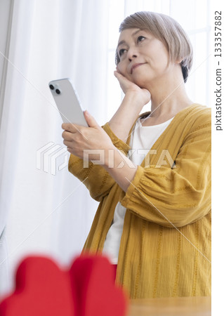 Senior woman using a matching app on her smartphone Senior woman using a matching app on her smartphone 133357882