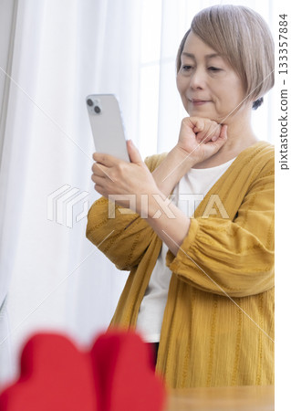 Senior woman using a matching app on her smartphone Senior woman using a matching app on her smartphone 133357884