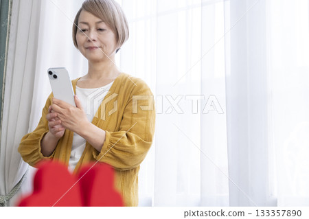 一位老年婦女正在使用智慧型手機上的配對應用程式 133357890